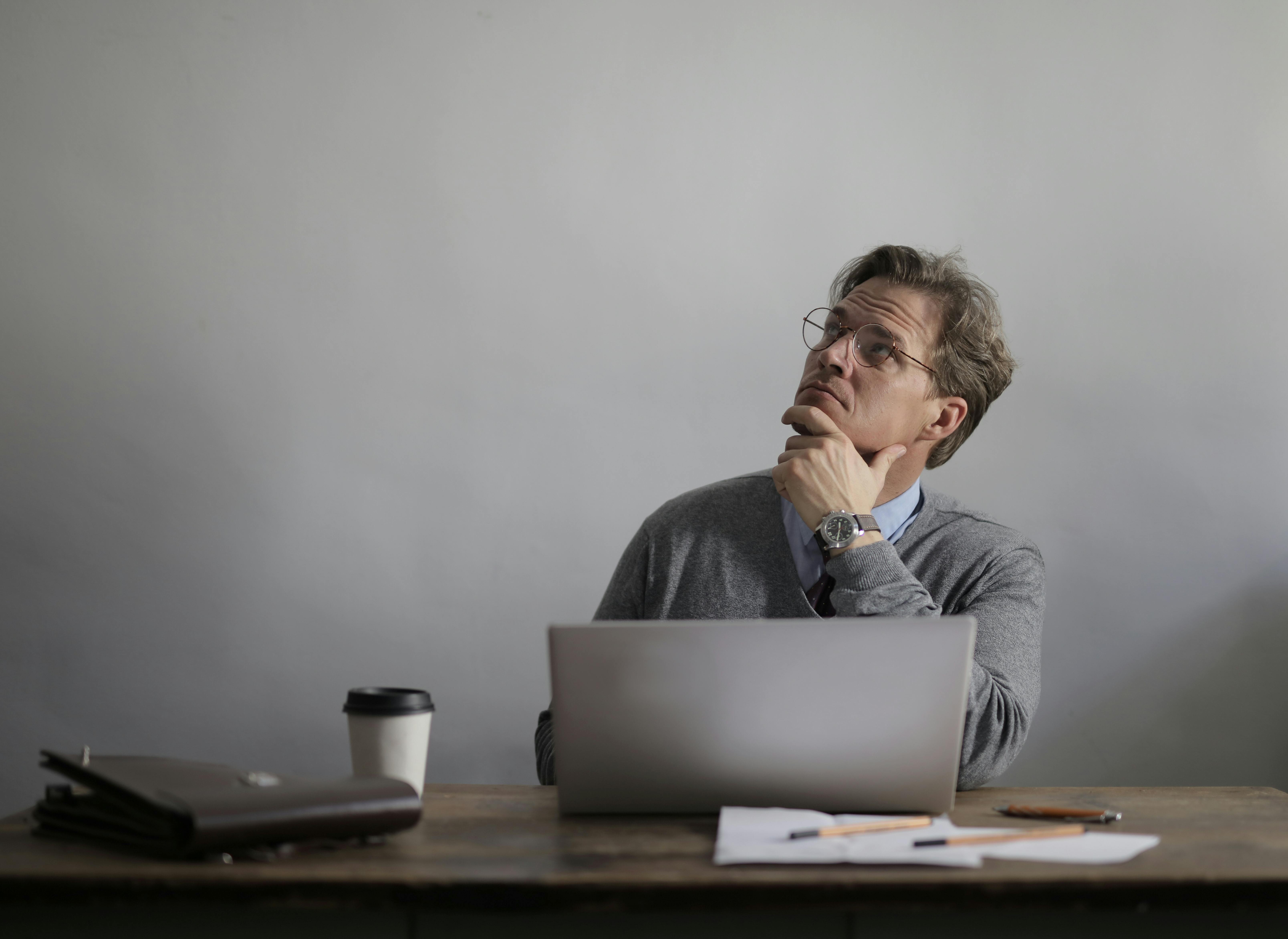 Homem analisando duvidas sobre atividade concomitante no notebook